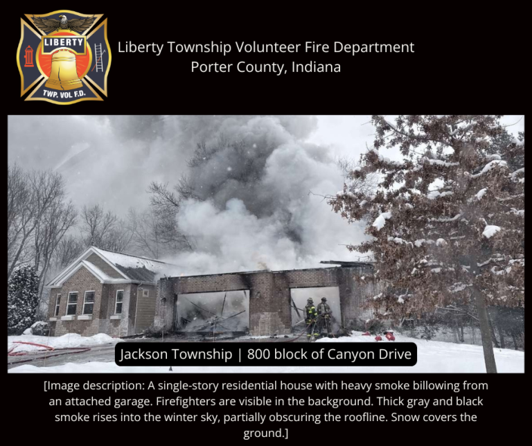 Single-story house with smoke billowing from an attached garage; snow covers the ground and roof. Two firefighters stand near the garage, partially obscured by thick gray and black smoke rising into a cloudy winter sky.